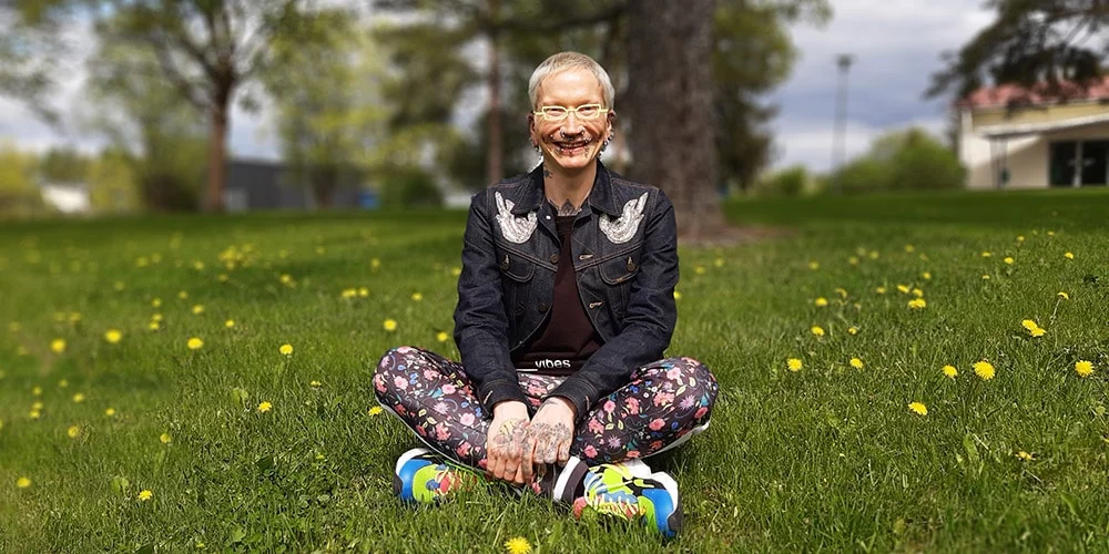 Hannu Viitala istuu keväisellä nurmikolla ja hymyilee