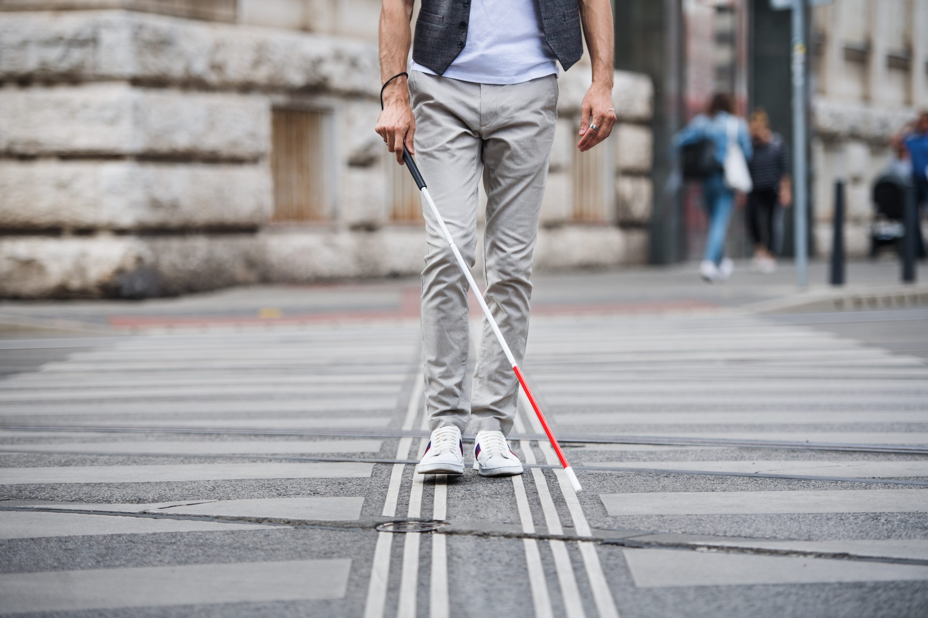 Pedestrian with a white cane on a crosswalk