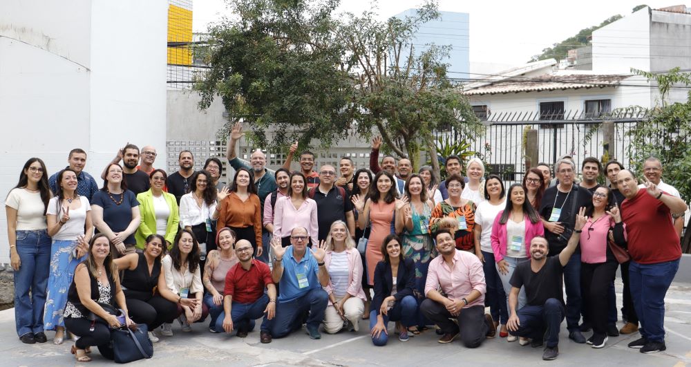 Project team members and teachers in IFES smiling and waving to the camera.