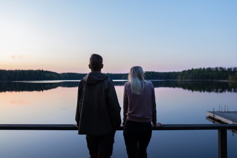 Kaksi henkilöä katselee järvelle