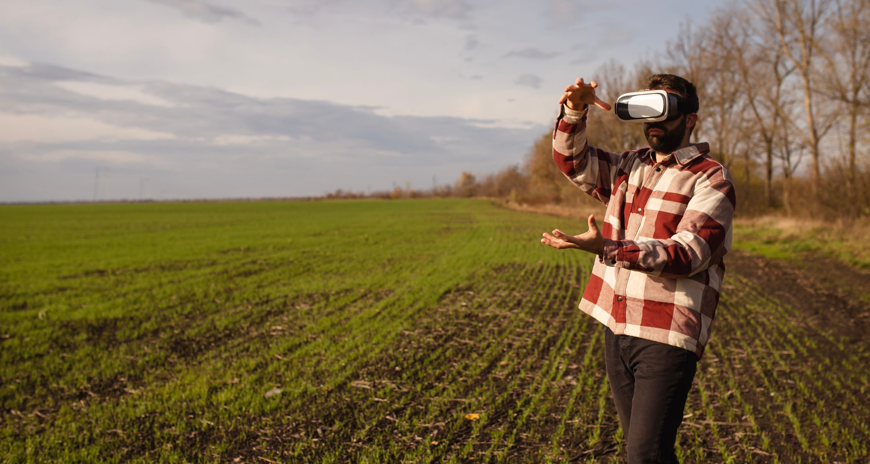 Henkilö pellolla VR-lasit päässä