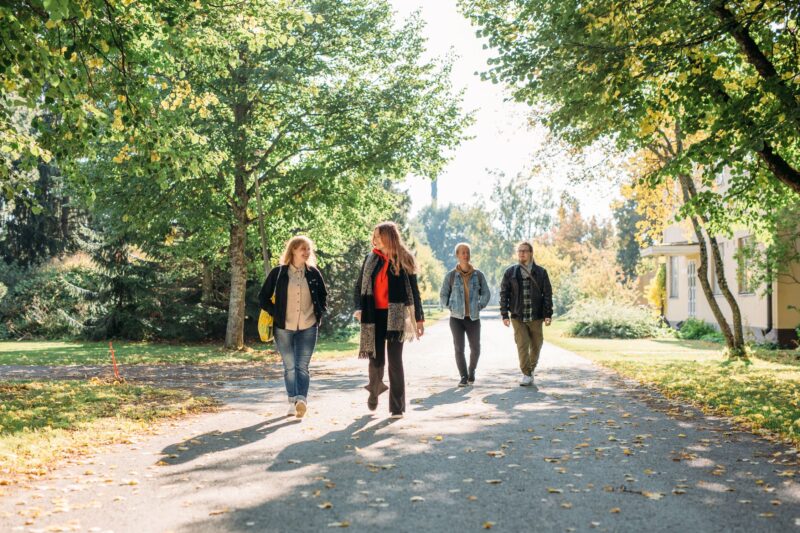 Neljä ihmistä kävelee ulkona.