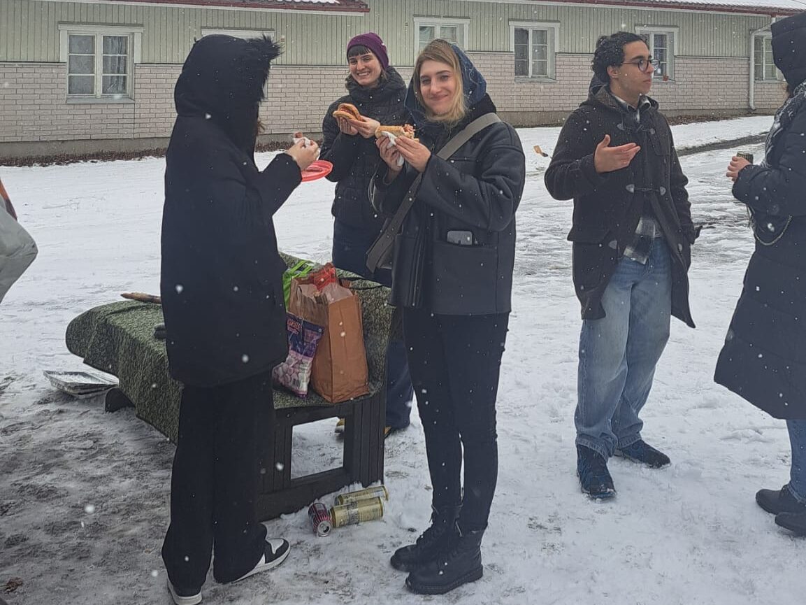 A few students standing outside and having snacks