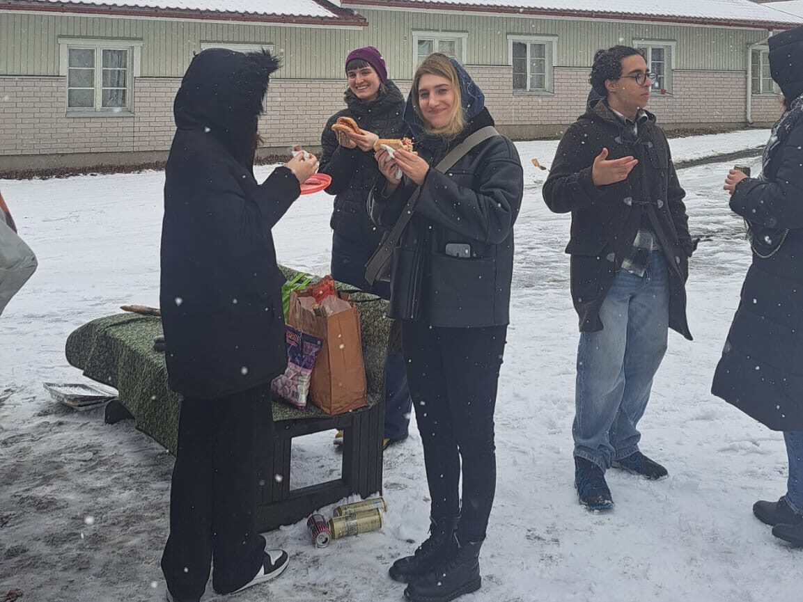 A few students standing outside and having snacks