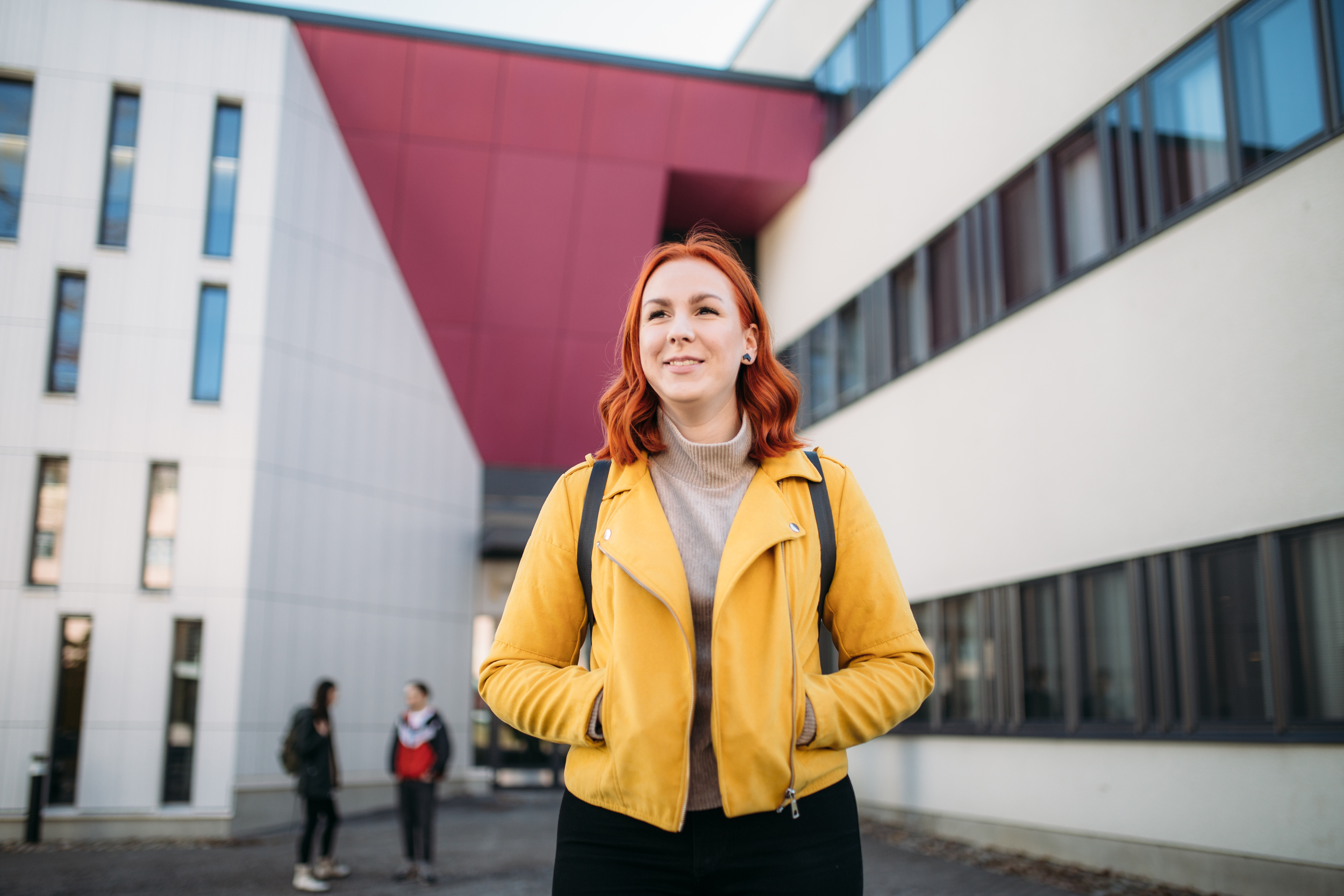 Woman standing outside of a building/Nainen seisoo rakennuksen ulkopuolella