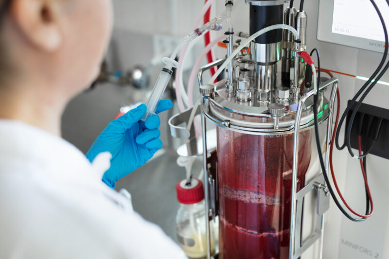 Henkilö työskentelee laboratoriovälineiden kanssa