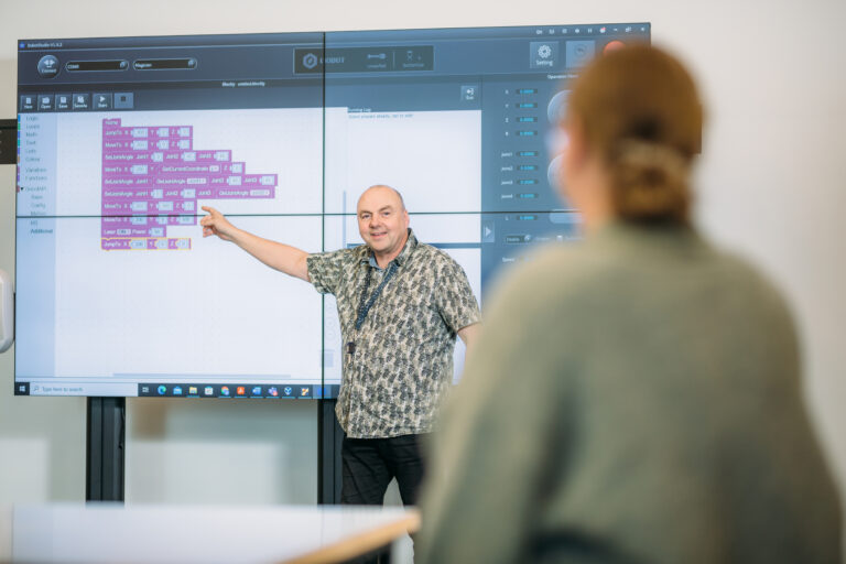 Man showing something on a screen/Mies näyttää jotain näytöllä