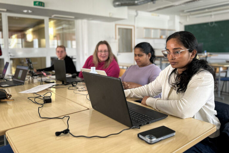 Student group working with computer in a class room.