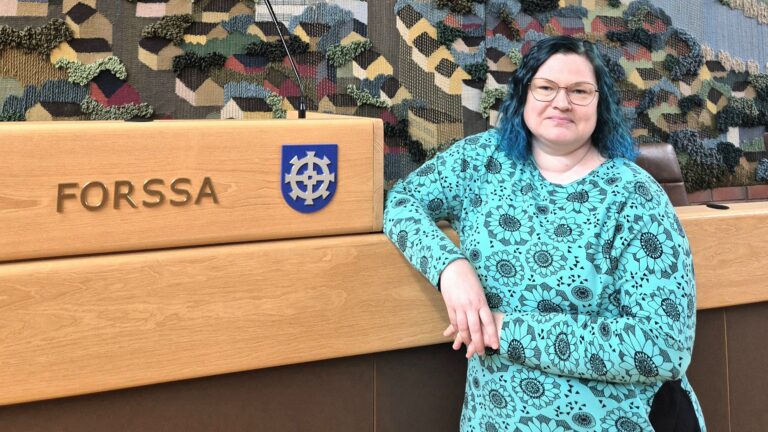 Katja Pouta, taustalla Forssa-teksti ja kaupungin vaakuna.