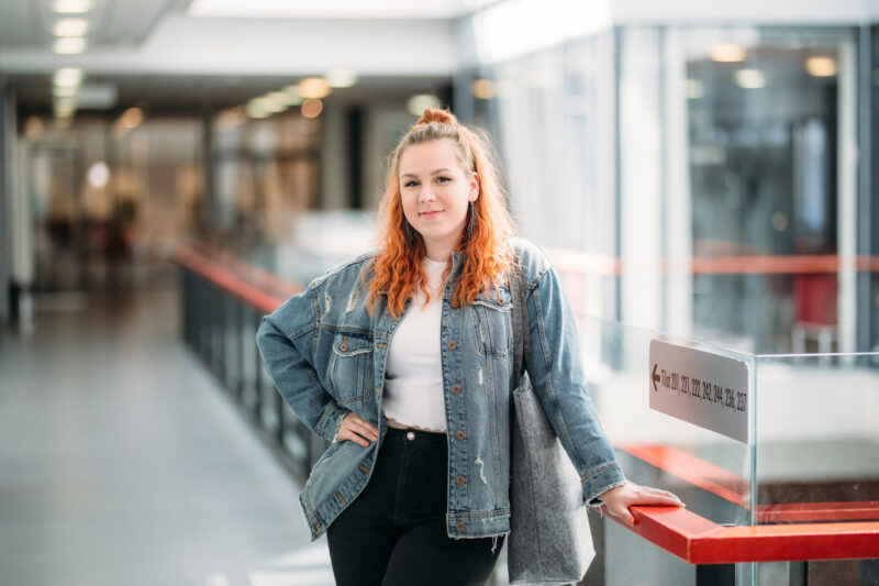 Nainn seisoo käytävällä/Woman standing at a hallway