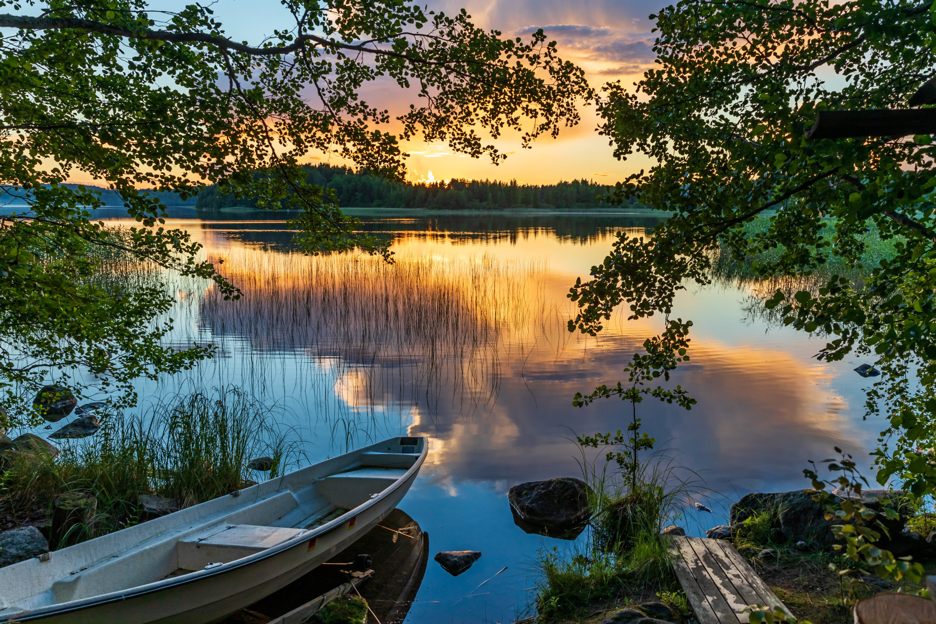Boat in the nature- at the shore of a lake in the sunset