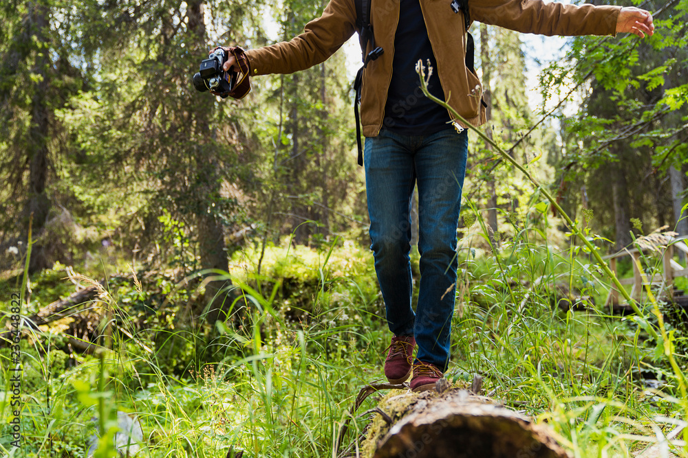 Person balancing on a log in the nature