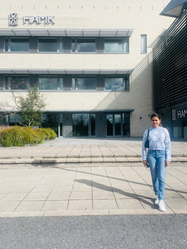 International Business student Hansani standing in front of the HAMK Valkeakoski campus.