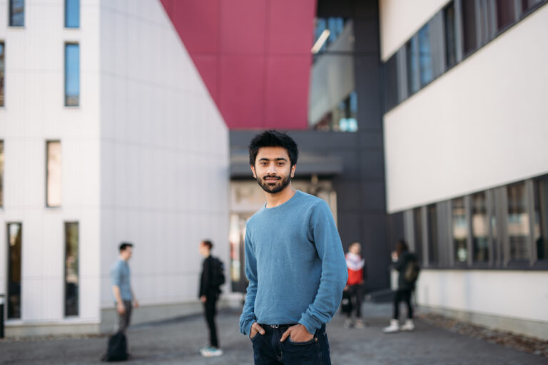 A man standing in front of a building/Mies seisoo rakennuksen edessä