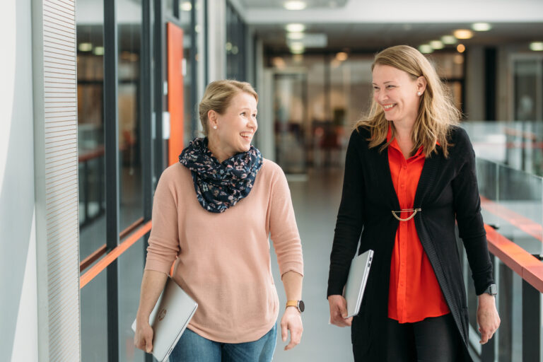 Two women are walking on a hallway/ Kaksi naista kävelee käytävällä