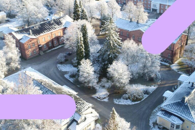 Mustialan kampuksen ilmakuva talvella lumisessa maisemassa