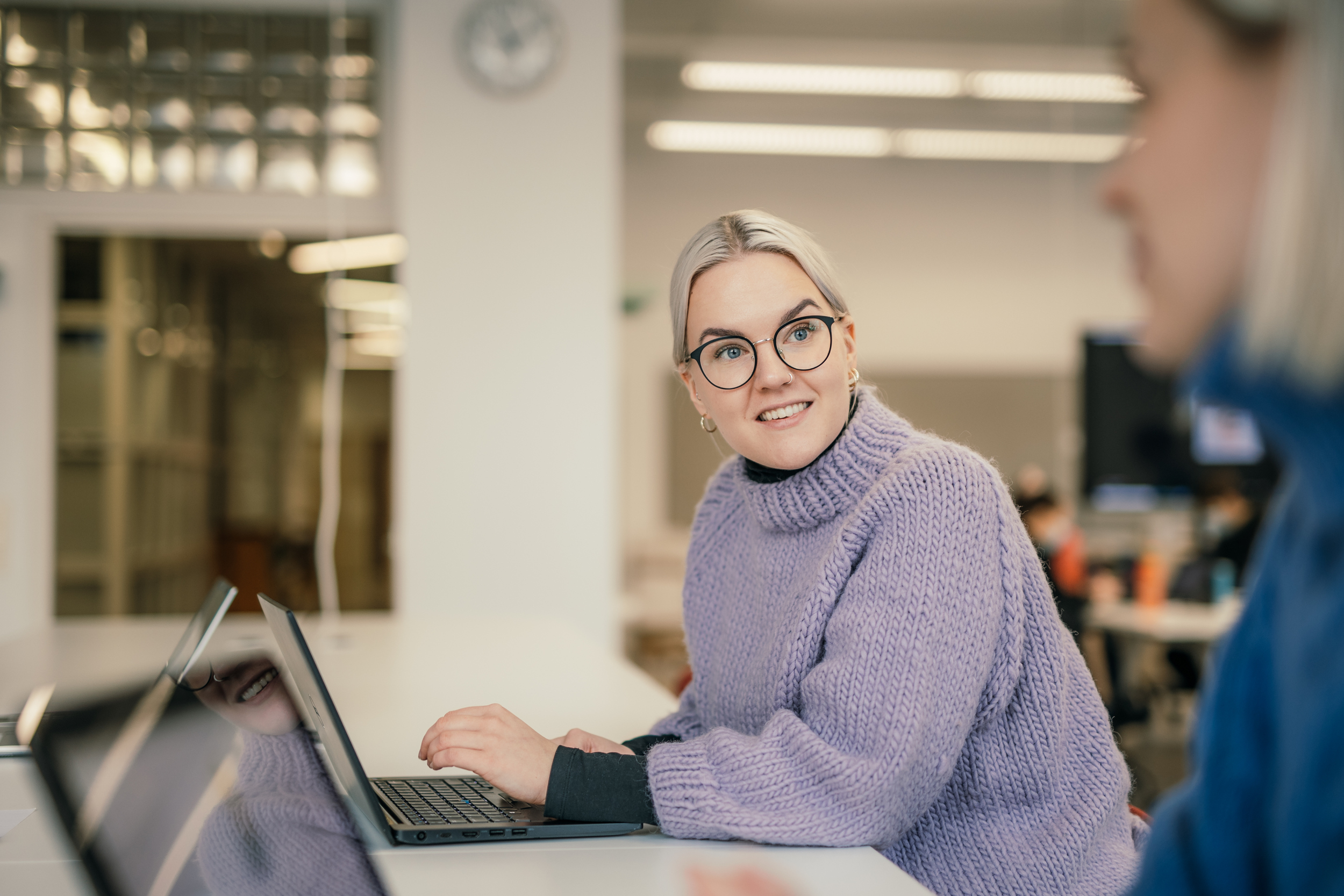 Nainen istuu tietokonella/Woman is sitting with a laptop