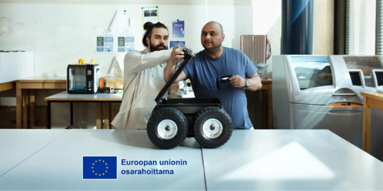 Two men in a laboratory setting examining and adjusting a small four-wheeled robot on a table.