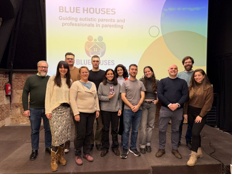 Project members smiling at the camera in front of BLUEHOUSES sign