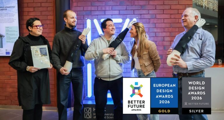 Älyhihan tehnyt tutkimusryhmä juhlimassa menestystään design-kilpailussa. Kuvassa viisi hymyilevää ihmistä ja