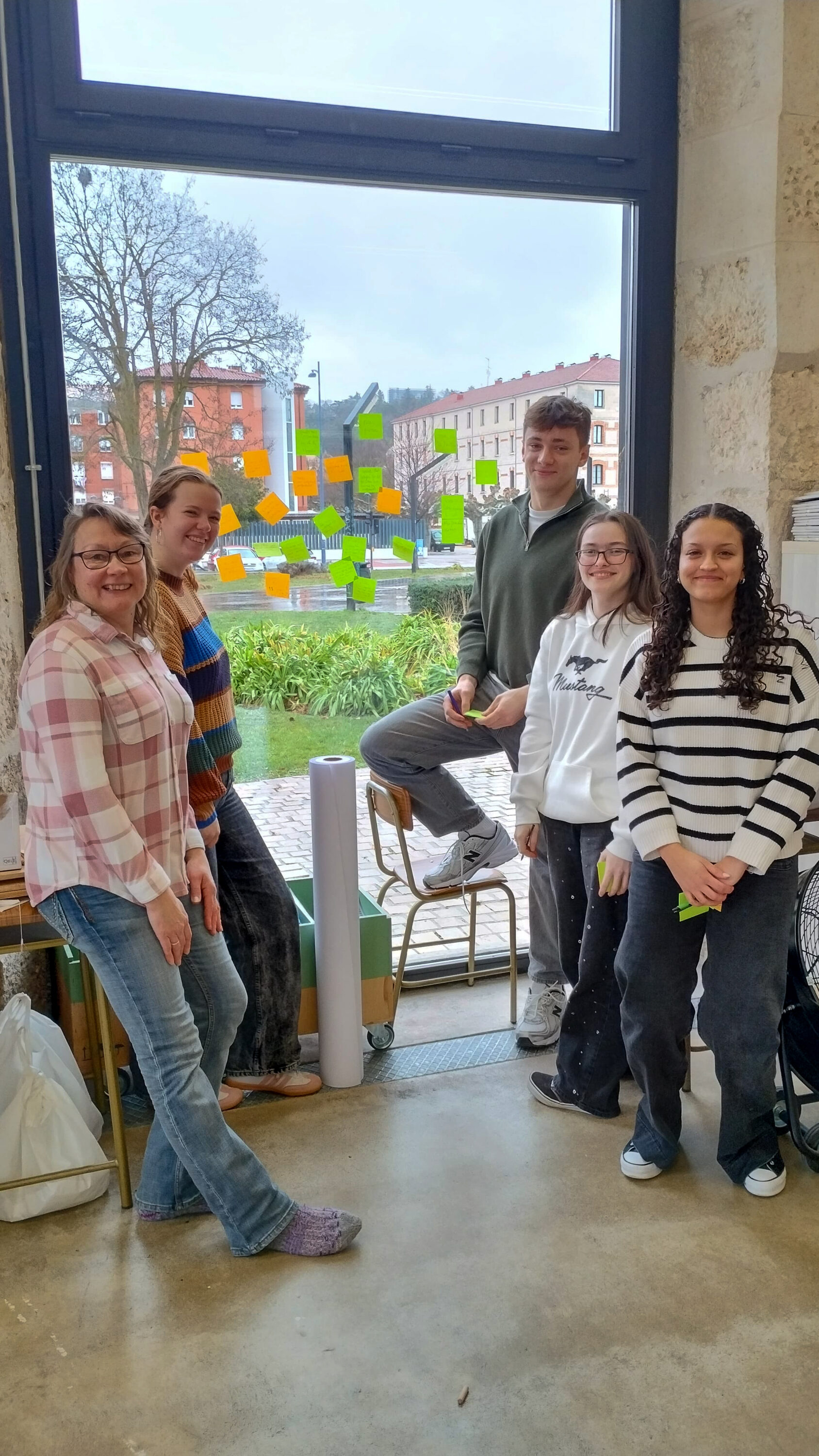 Opiskelijoita poseeramassa ikkunan edessä