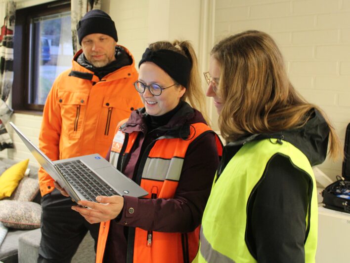 Rakennus- ja yhdykuntatekniikan lehtorit Lauri Helminen ja Jenni Ypyä tarkastelemassa Lotan kanssa päivän mittaustuloksia.