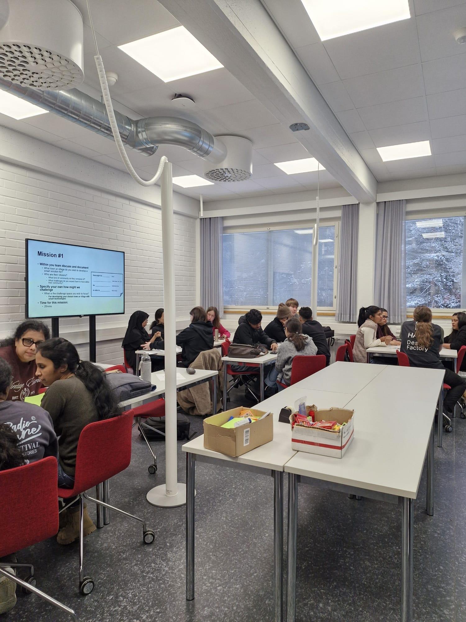 Henkilöitä pöytien ääressä keskustelemassa