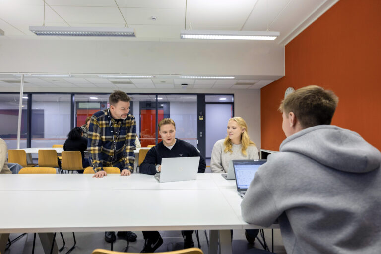 Opettaja ohjaa opiskelijoita