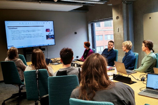 Ihmisiä kokouspöydän ääressä