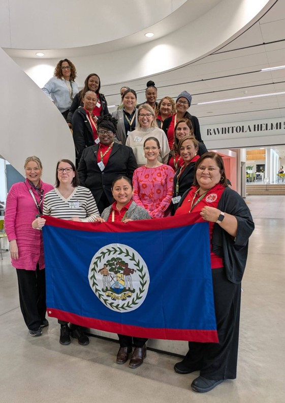 Belize flag holded by people who are standing and smiling