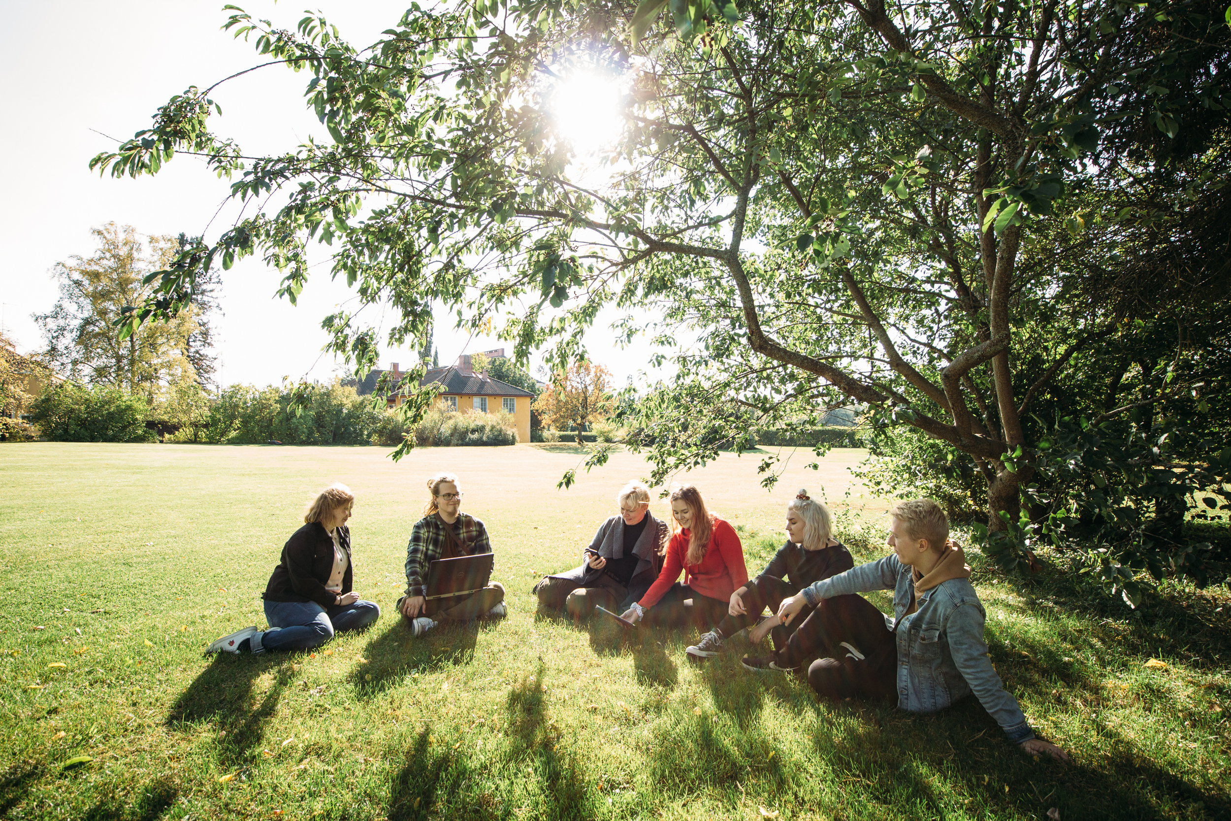 Ihmisiä istumassa puutarhassa/ People sitting in a garden